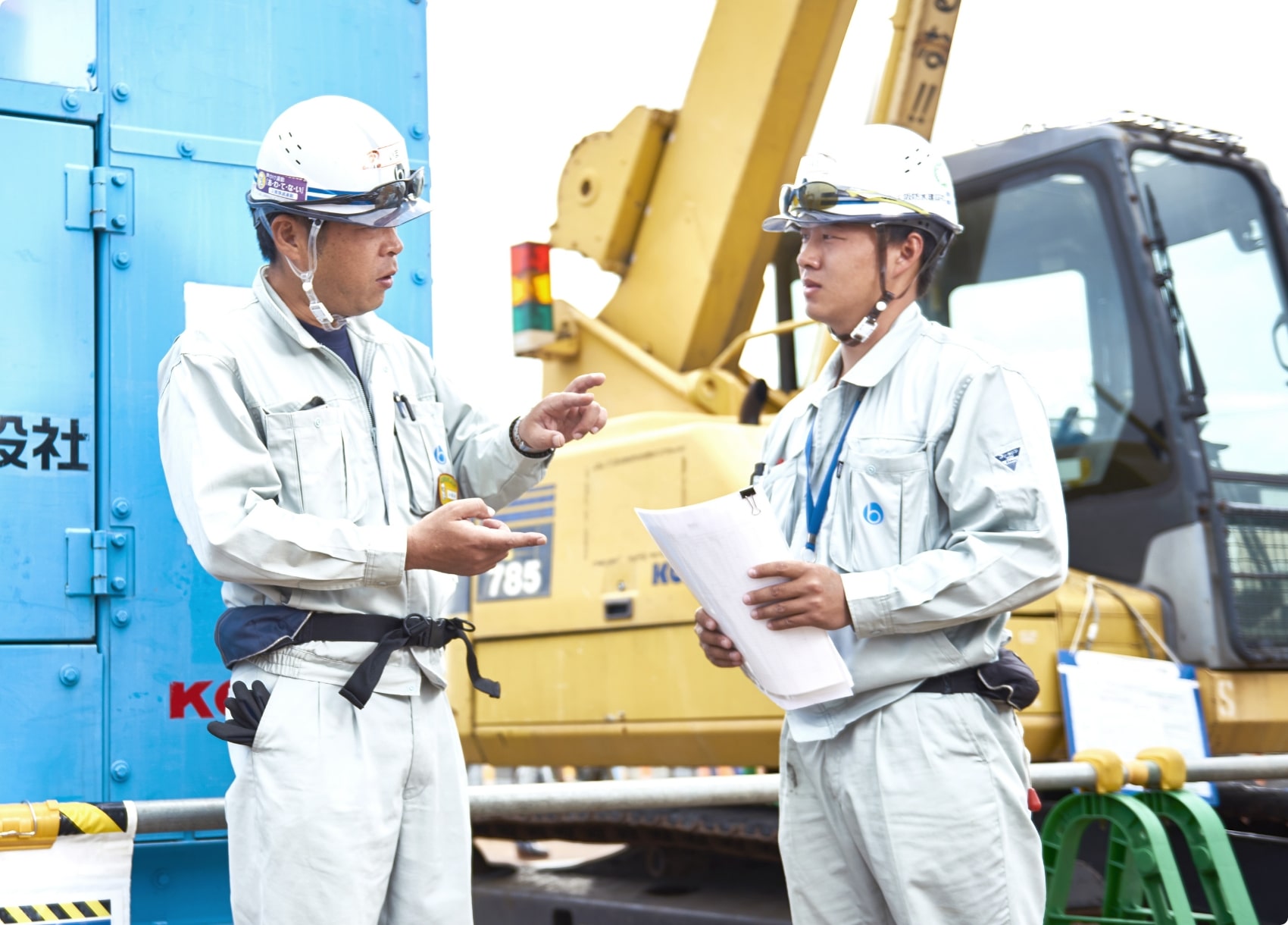 立って話をする2人の作業員
